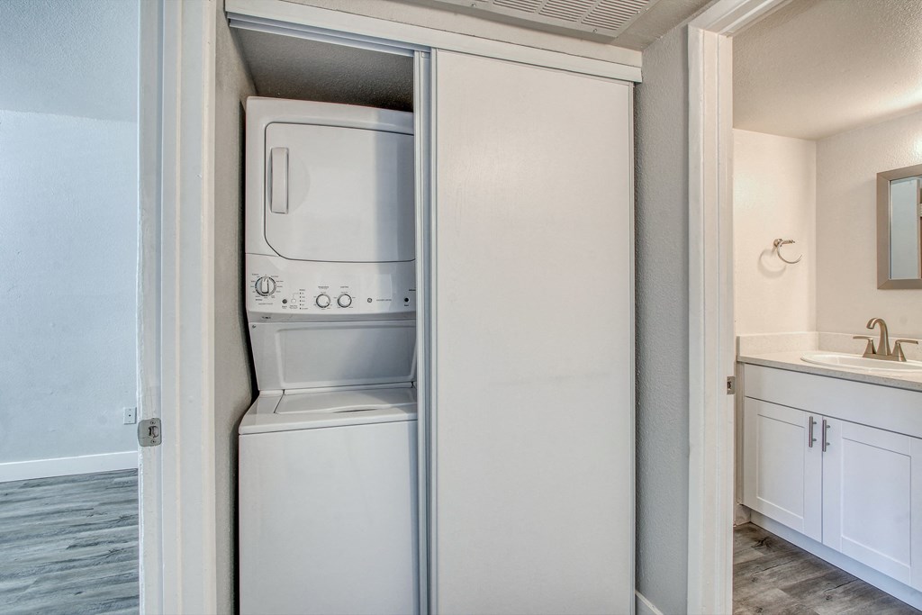 an empty kitchen with a refrigerator and a washer and dryer