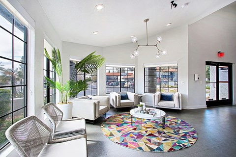 A white living room with a colorful rug on the floor.