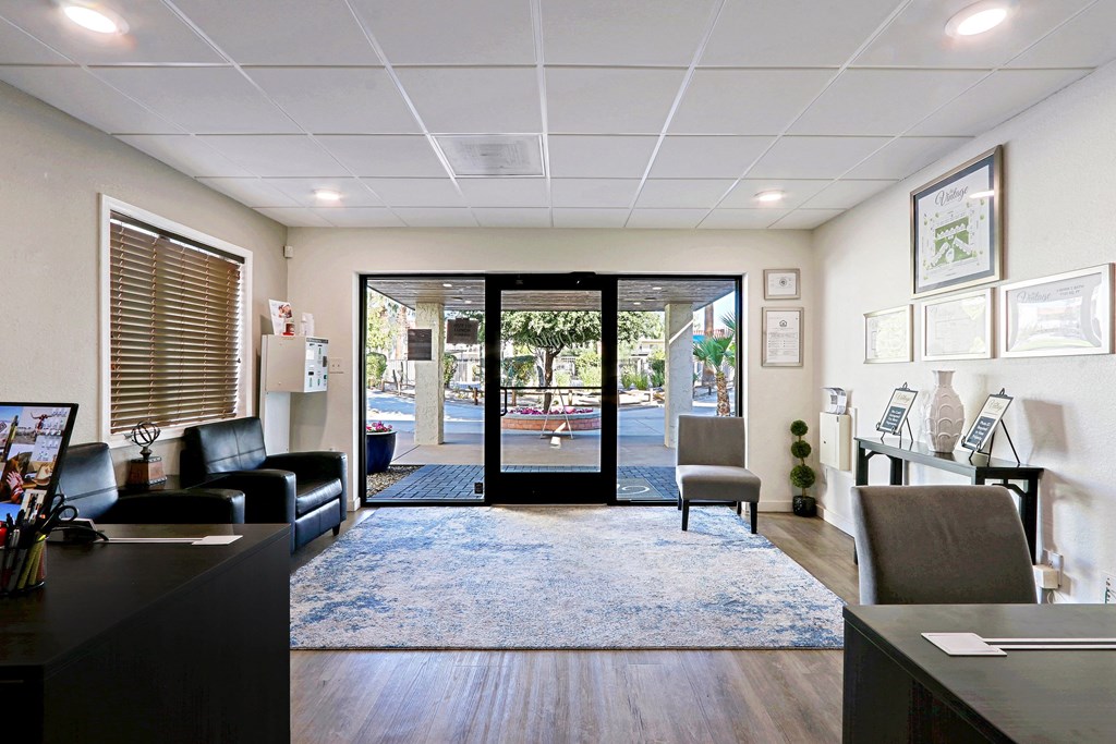 A reception area with a black couch, a desk, and a framed picture on the wall.
