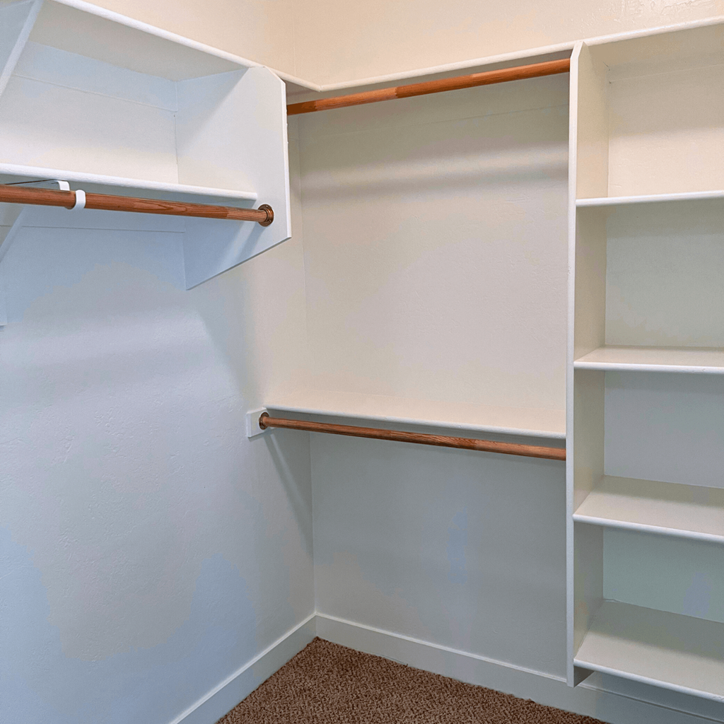 a walk in closet with shelves and a rail on the wall