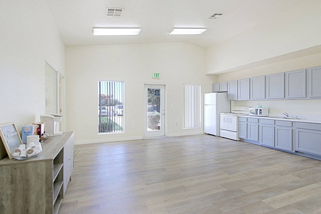an empty kitchen with white appliances and blue cabinets