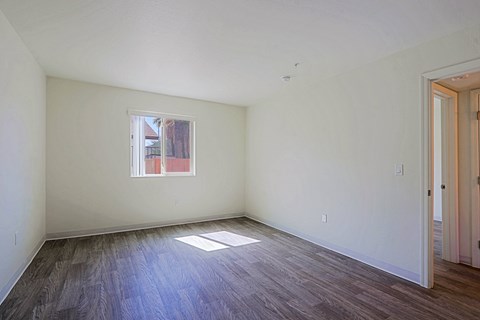 A room with a window and wooden floors.