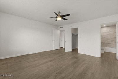 an empty living room with a ceiling fan