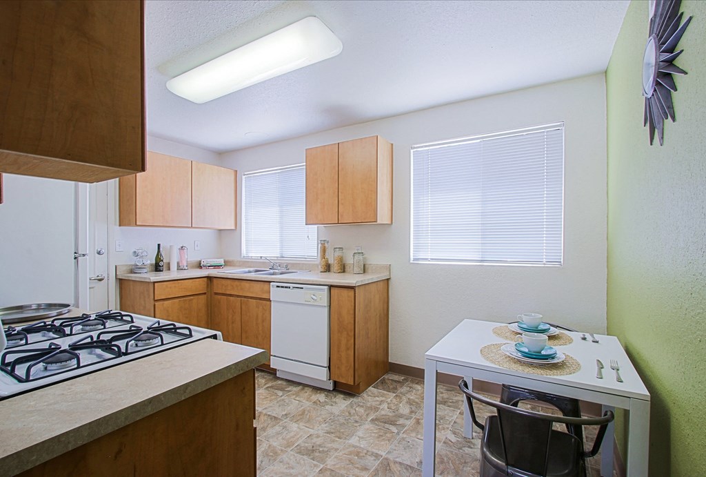 a kitchen with wooden cabinets and a white table