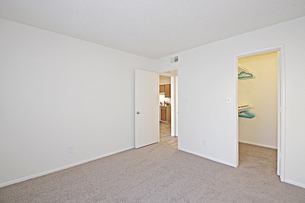 a bedroom with white walls and carpet