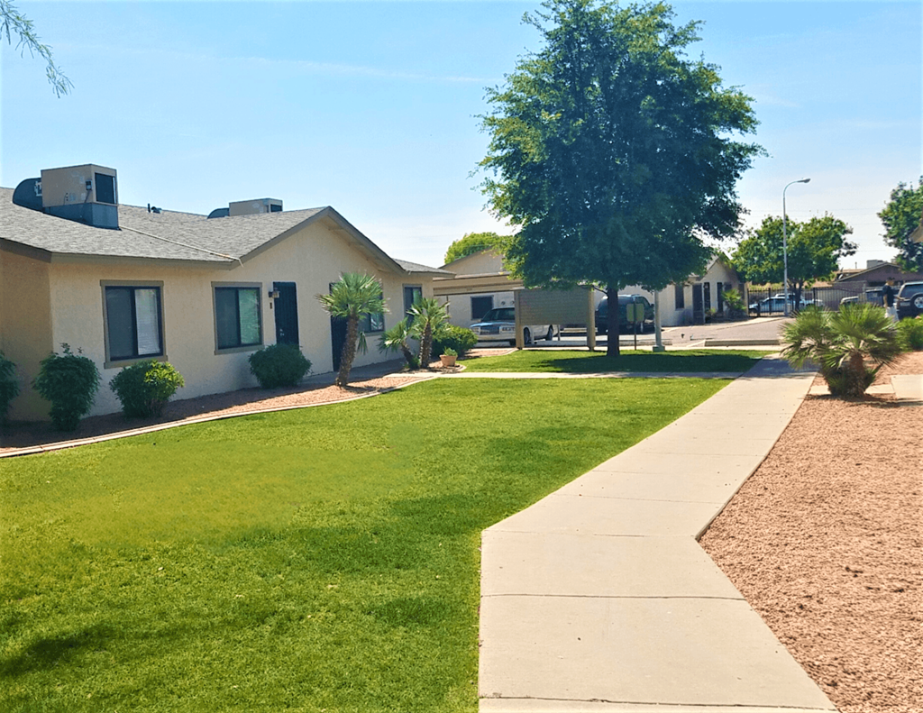 a row of houses in a neighborhood with a green lawn