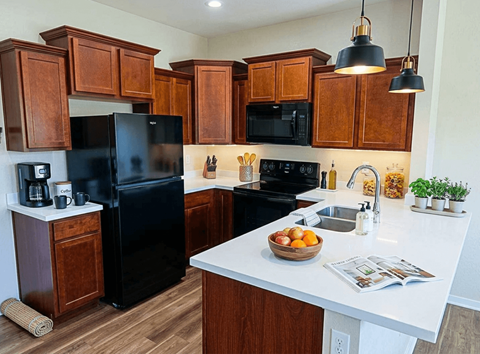 A kitchen with black appliances and wooden cabinets.