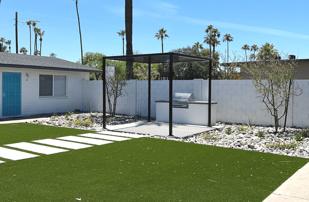 A white house with a blue door and a white fence.