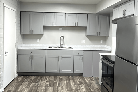 A kitchen with a sink and a refrigerator.