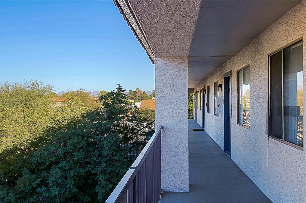 a balcony with a view of a building and trees