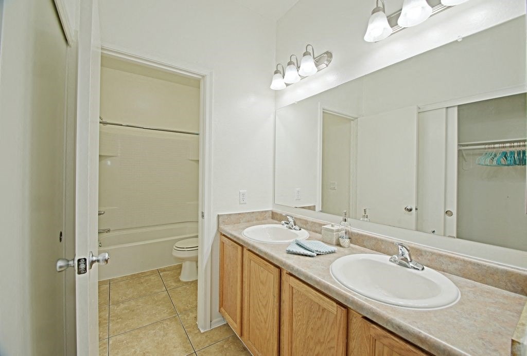 a bathroom with two sinks and a shower and a toilet