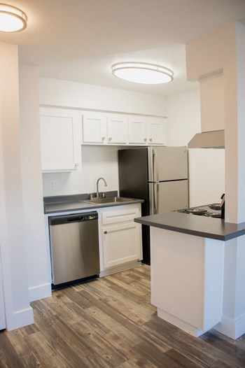 a kitchen with white cabinets and black countertops - Photo Gallery 12