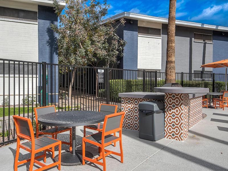 a patio with tables and chairs in front of a building