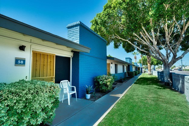A blue house with a white chair in front of it.