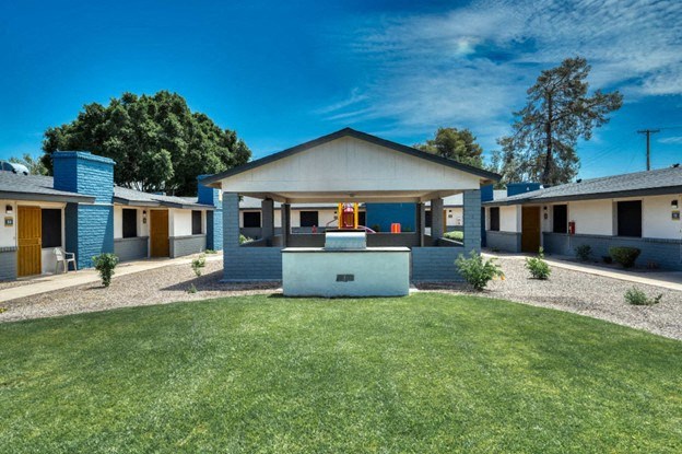 A modern resident clubhouse with a blue roof and a white garage at Connect on University, Mesa, 85203
