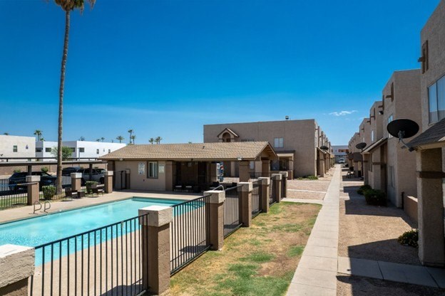 A row of houses with a pool in the foreground.