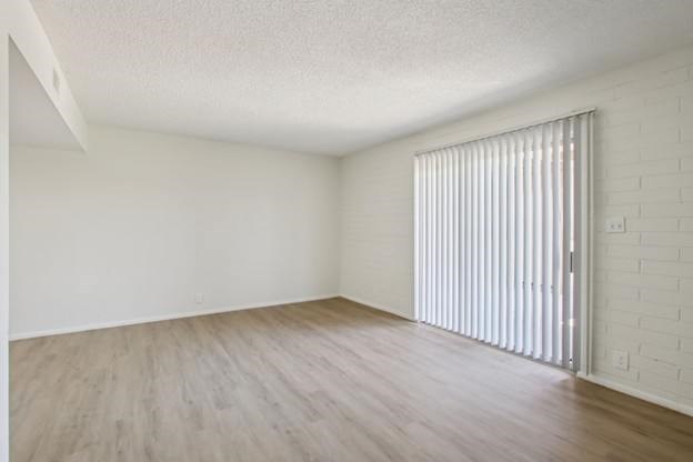 A room with a white wall and wooden floor.