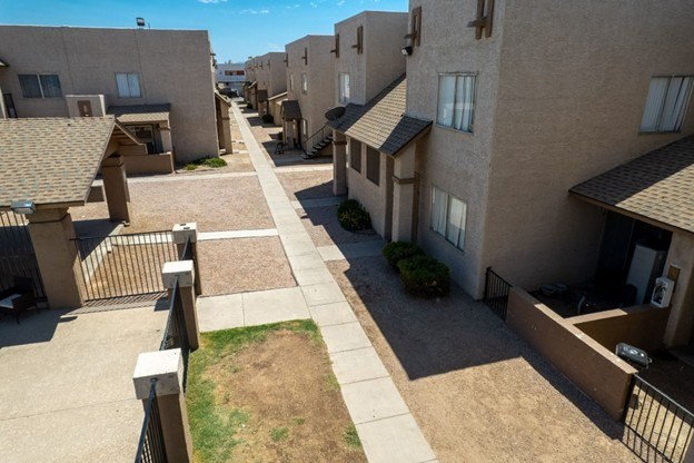 A row of houses with a sidewalk in between.
