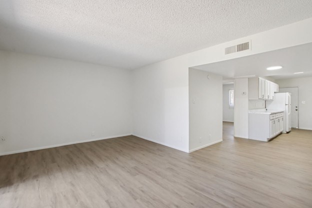 A room with wooden flooring and white walls.