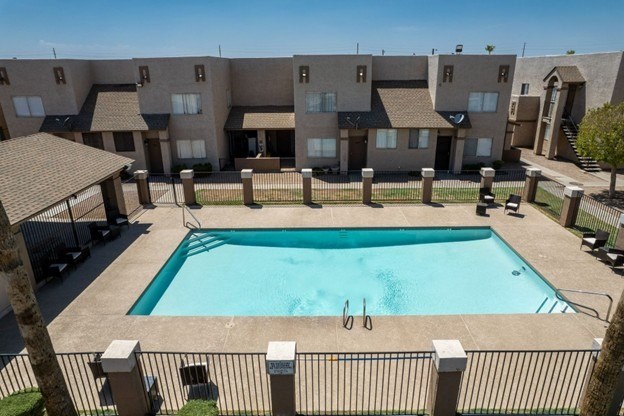 A swimming pool in front of apartment buildings.