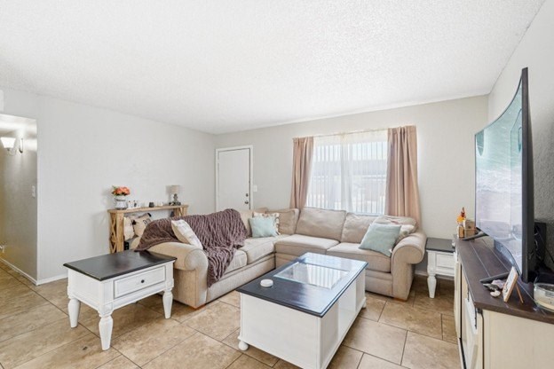 A living room with a couch, coffee table, and television.