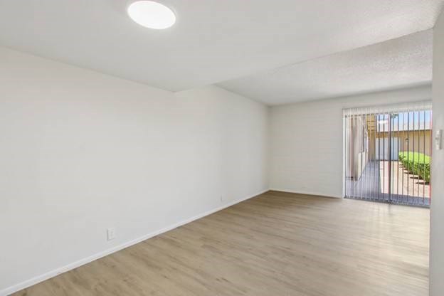 A room with wooden flooring and white walls.
