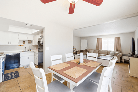 A kitchen with a dining table and chairs.