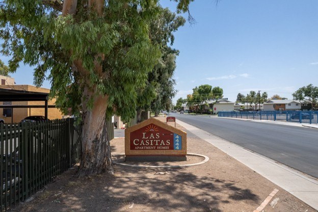A sign for the Castitas Apartment Homes is in front of a tree.