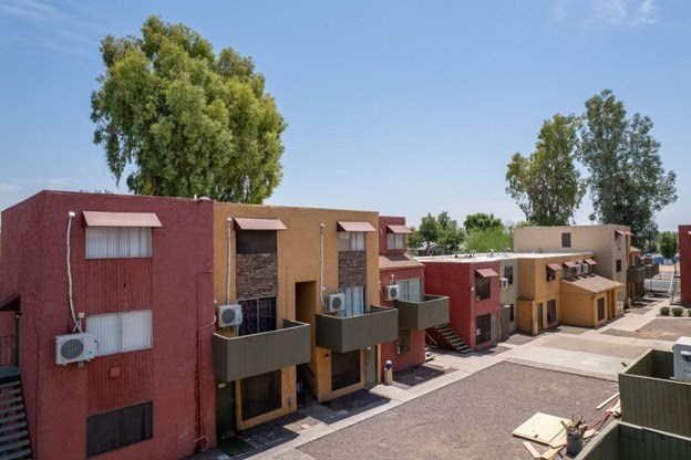 A row of houses with a tree in the background.