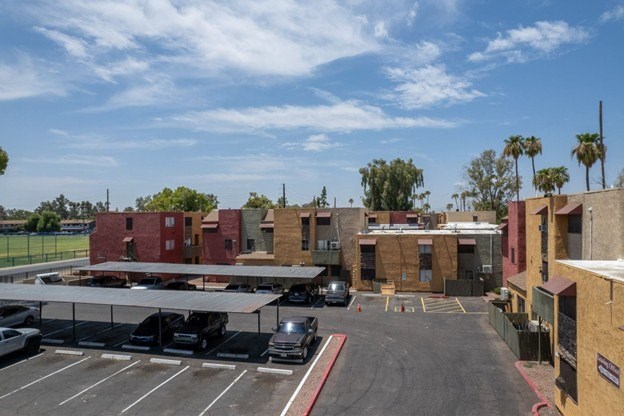 A parking lot with cars and a building in the background.
