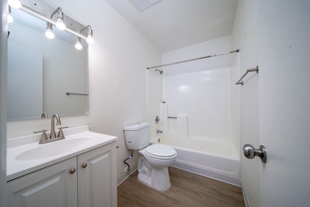 A white bathroom with a toilet, sink, and bathtub.