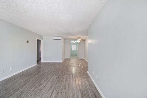 A room with wooden flooring and white walls.