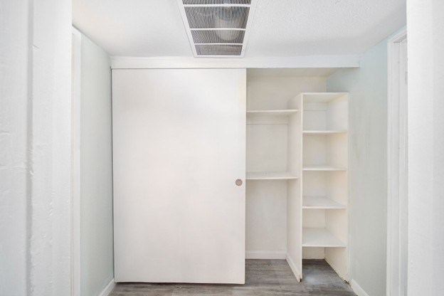 A white door is open to a room with shelves.