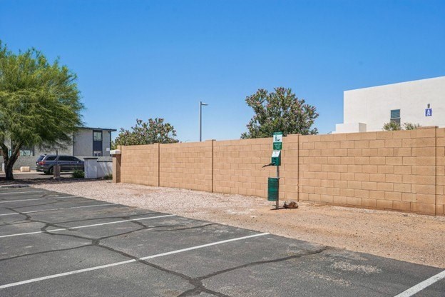 A parking lot with a wall and a tree.