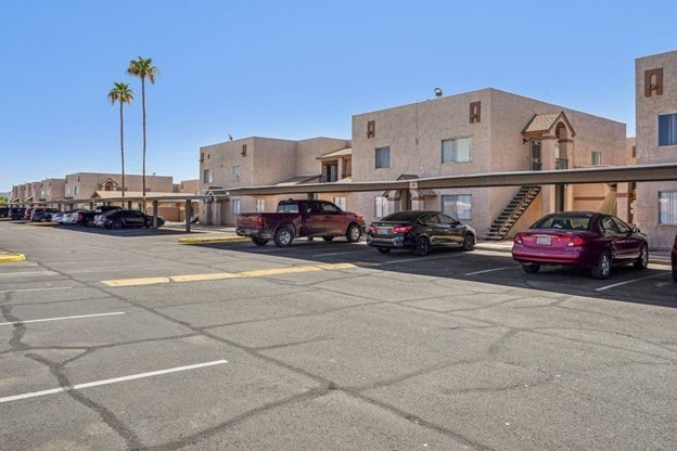 A parking lot with cars and a building in the background.