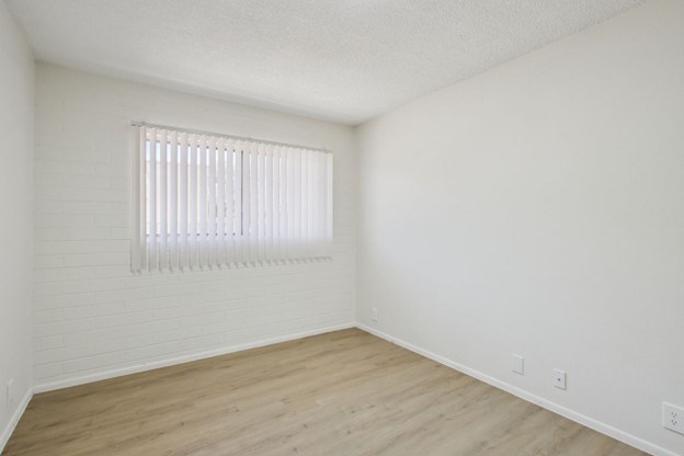 A room with a window and wooden floors.