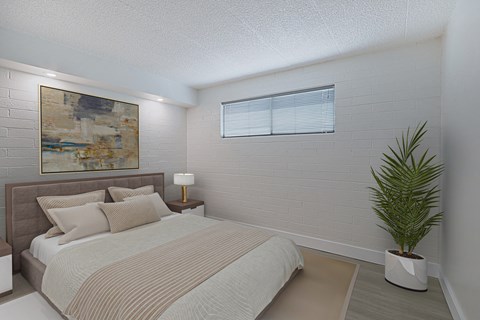 A bedroom with a bed, lamp, and a painting on the wall.