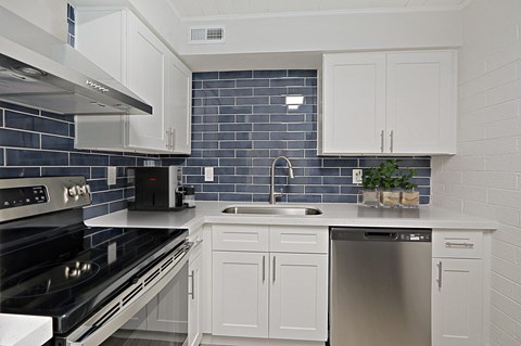 a kitchen with white cabinets and black and white appliances