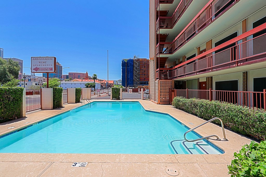 A swimming pool in a sunny outdoor pool area.