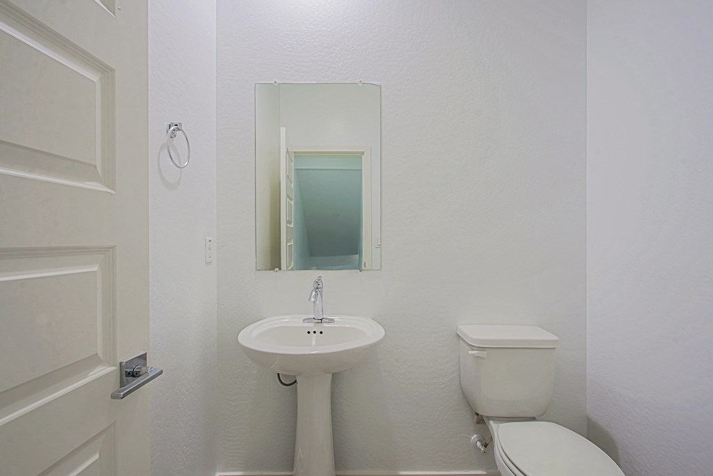 a bathroom with a sink toilet and a mirror