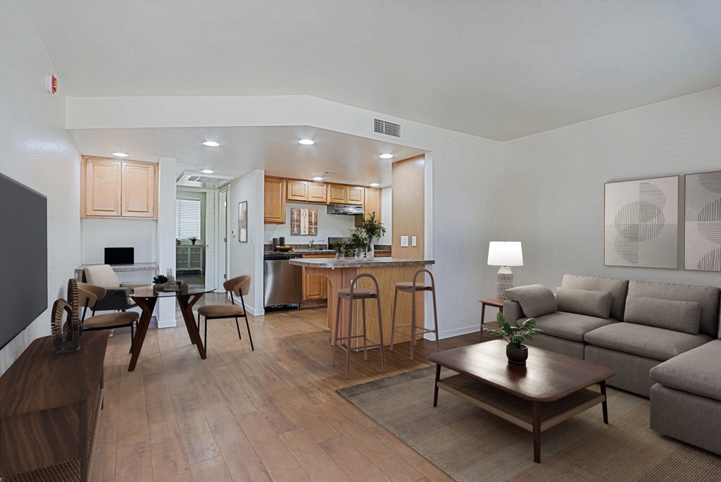 A modern living room with a kitchen in the background.