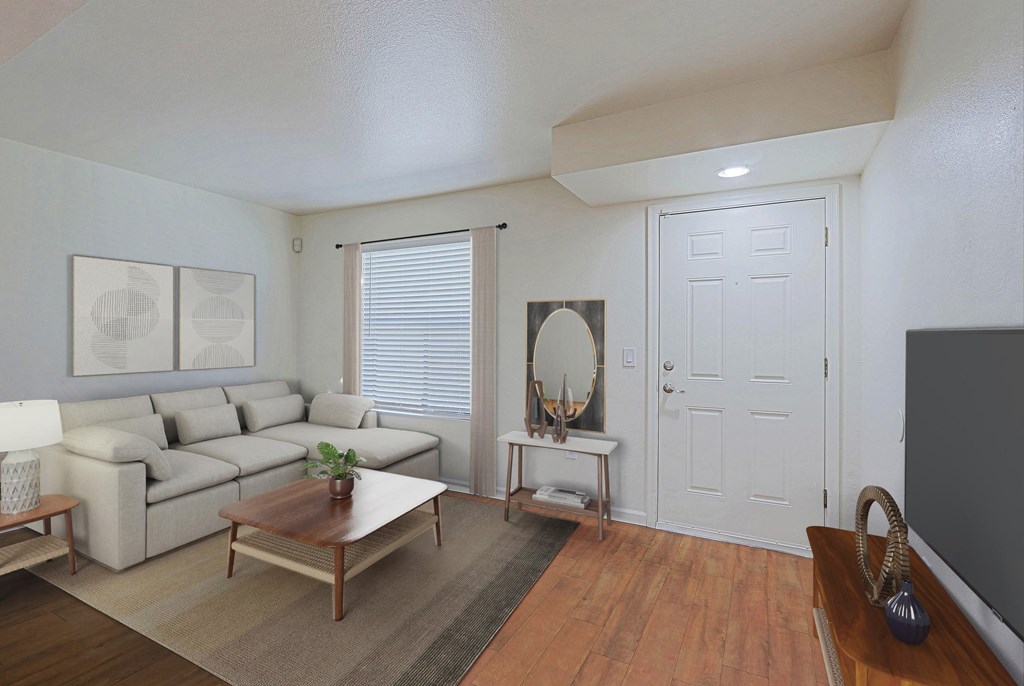 A living room with a white couch and a wooden coffee table.