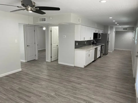 A kitchen with white cabinets and a ceiling fan.