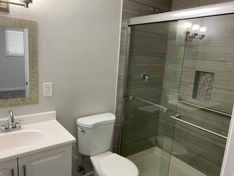 A white toilet sits next to a sink in a bathroom.