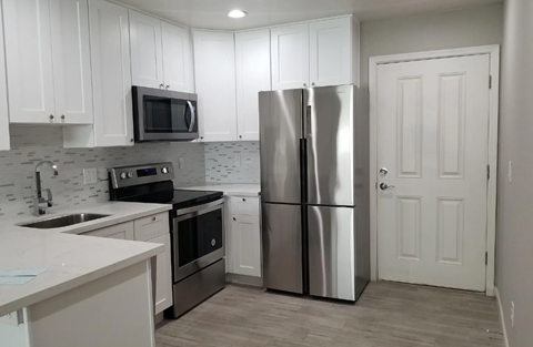 a kitchen with stainless steel appliances and white cabinets