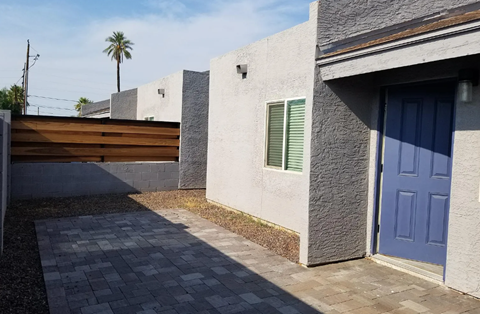 a house with a blue door and a walkway in front of it