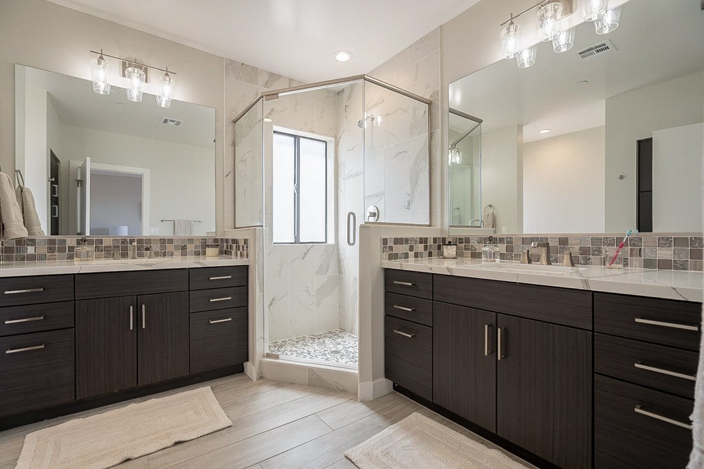 a large bathroom with two sinks and a shower
