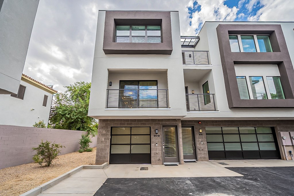 the front facade of a condo building with glass doors and windows