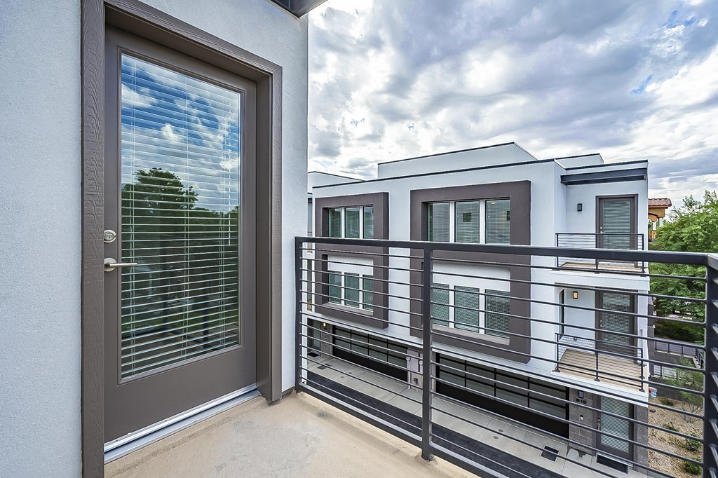 a balcony with a door and a view of a building
