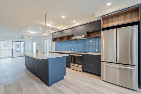 a large kitchen with stainless steel appliances and blue cabinets
